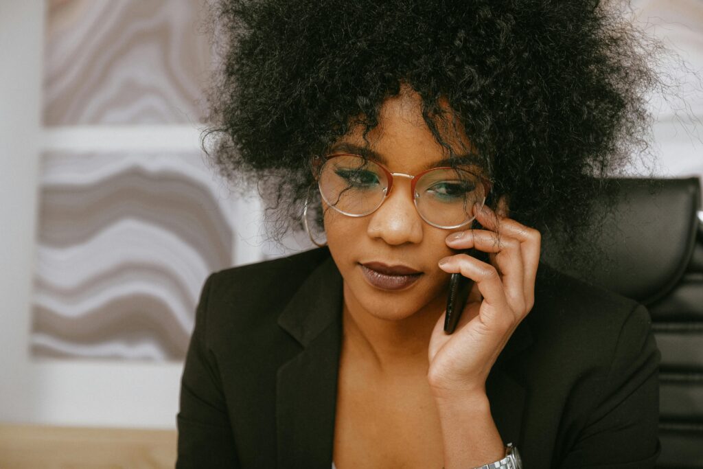 African American businesswoman in office, focused on phone call and tasks.